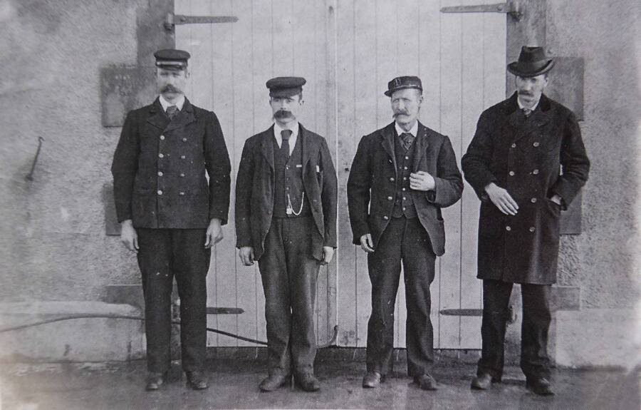 三名守塔人与主管的合照。约 1900 年的合照。从左至右是 James Ducat、Thomas Marshall、Donald McArthur 和主管 Robert Muirhead；第四人不是后来登岛的 Joseph Moore。